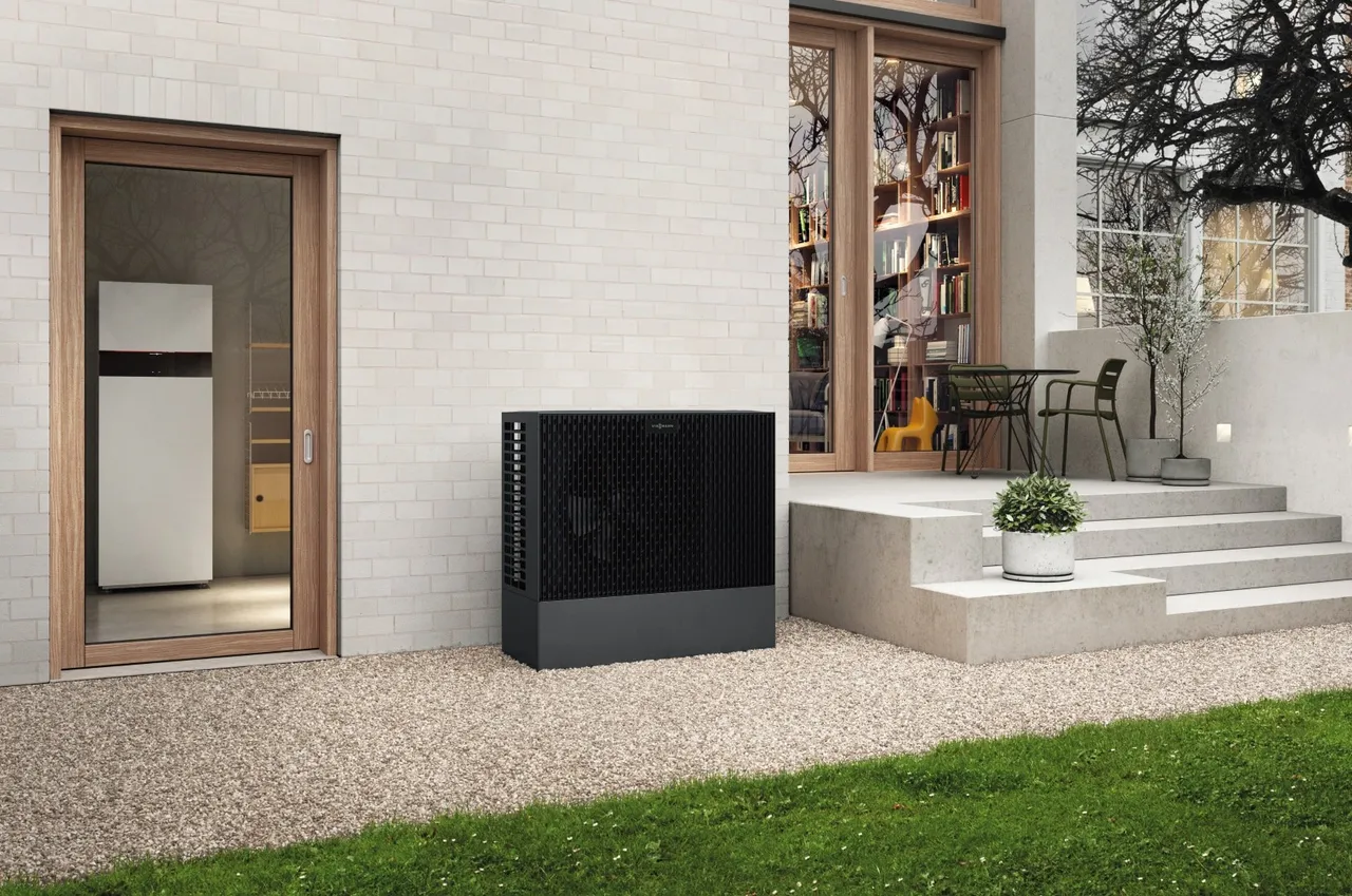 Viessmann Vitocal 222-S Außeneinheit an einem Wohnhaus, die Inneneinheit steht im Technikraum dahinter
